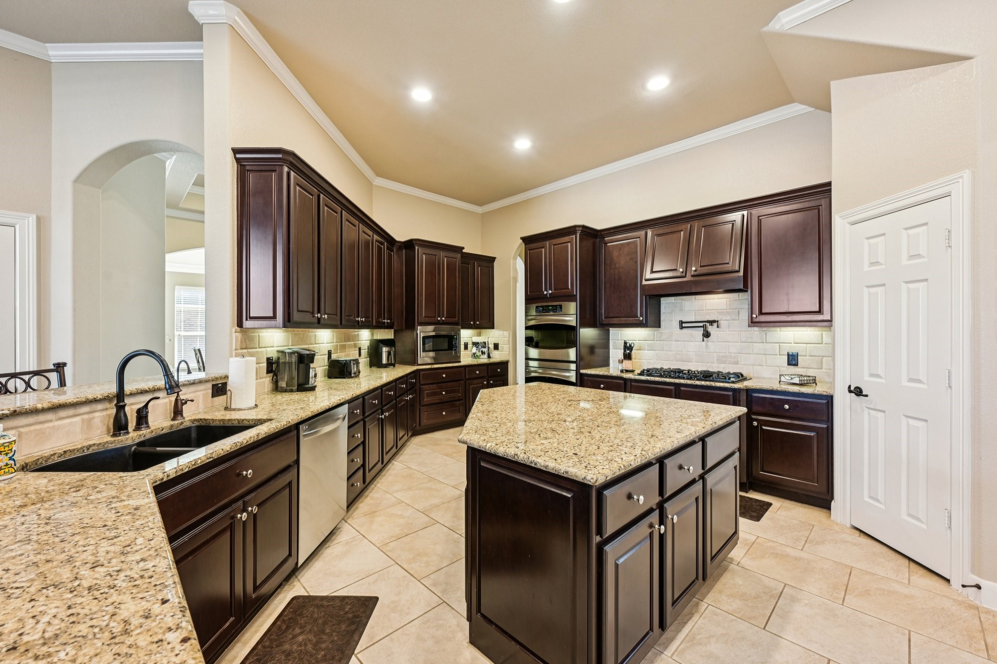 25214 East Titan Springs Drive Spring, TX 77389 - Photo 18 of 44 a kitchen with kitchen island granite countertop a sink stove and refrigerator