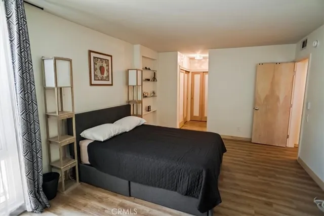 a bedroom with a bed and wooden floor