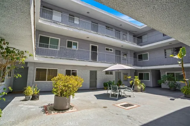 a view of a patio with a table and chairs under an umbrella