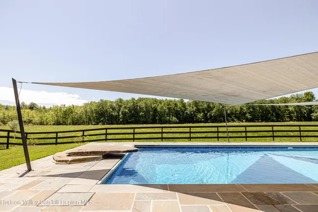 a dining room with furniture water view and a floor to ceiling window