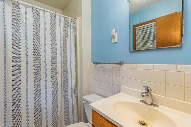 a bathroom with a sink a mirror and a shower curtain