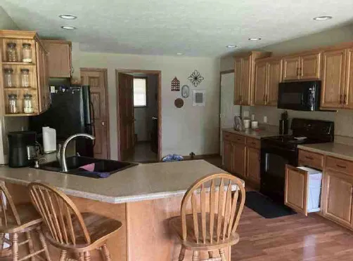 a kitchen with granite countertop a refrigerator and a sink