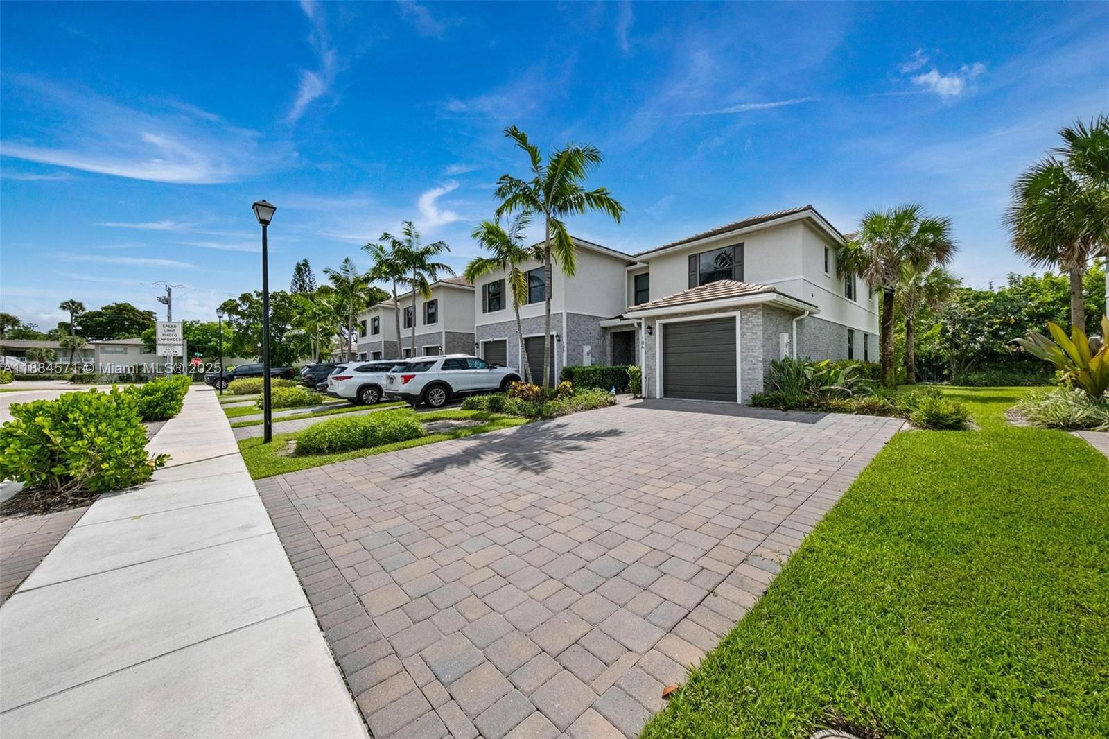 186 Southeast 5th Court, Unit 186 Deerfield Beach, FL 33441 - Photo 1 of 10 a front view of a house with a yard and potted plants