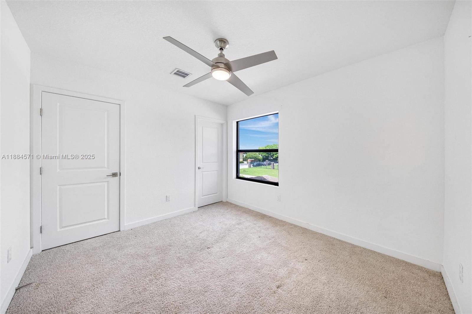 186 Southeast 5th Court, Unit 186 Deerfield Beach, FL 33441 - Photo 9 of 10 an empty room with windows and fan