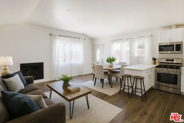 a living room with furniture a dining table and a fireplace