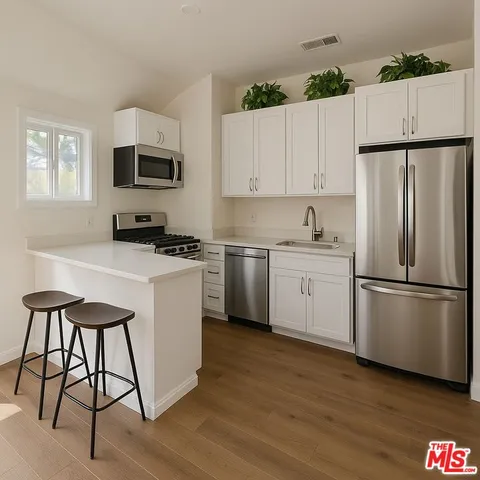 a kitchen with stainless steel appliances a refrigerator sink and white cabinets
