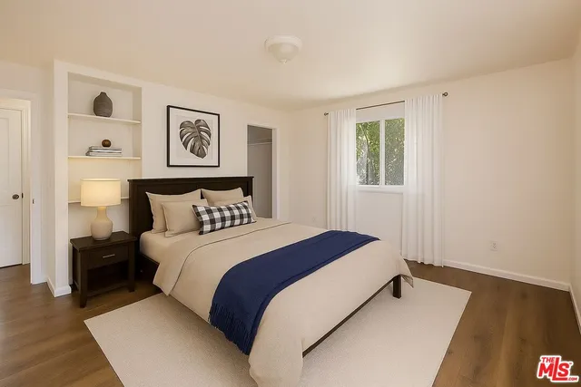 a bedroom with bed and night stand