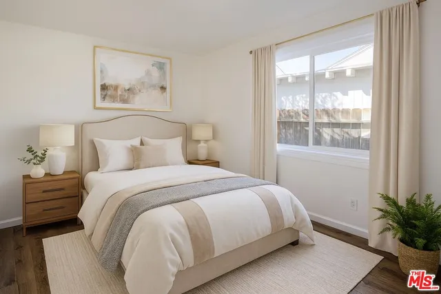 a bedroom with a large bed and a potted plant