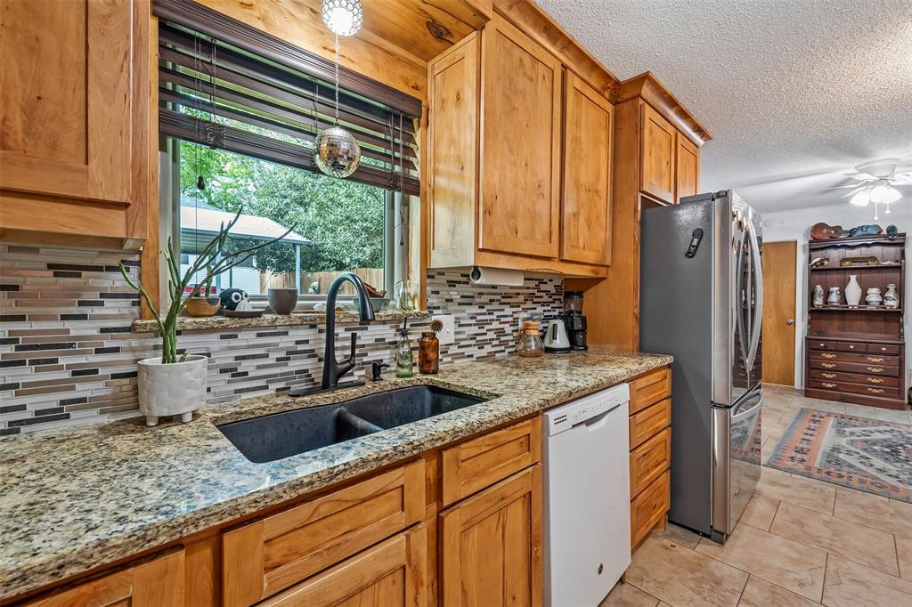 621 Athens Street Canton, TX 75103 - Photo 6 of 25 a kitchen with stainless steel appliances granite countertop a sink a refrigerator and a counter space