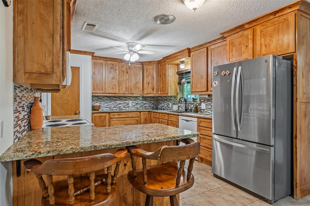 621 Athens Street Canton, TX 75103 - Photo 8 of 25 a kitchen with stainless steel appliances granite countertop a refrigerator a sink and a stove