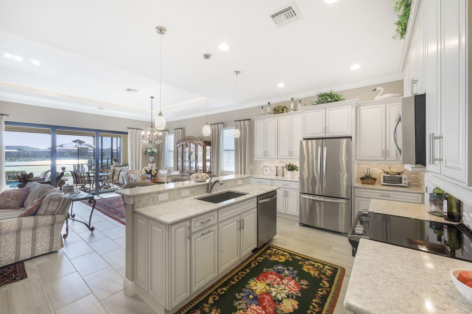 1433 Redona Way Naples, FL 34113 - Photo 11 of 50 a kitchen with sink cabinets and refrigerator