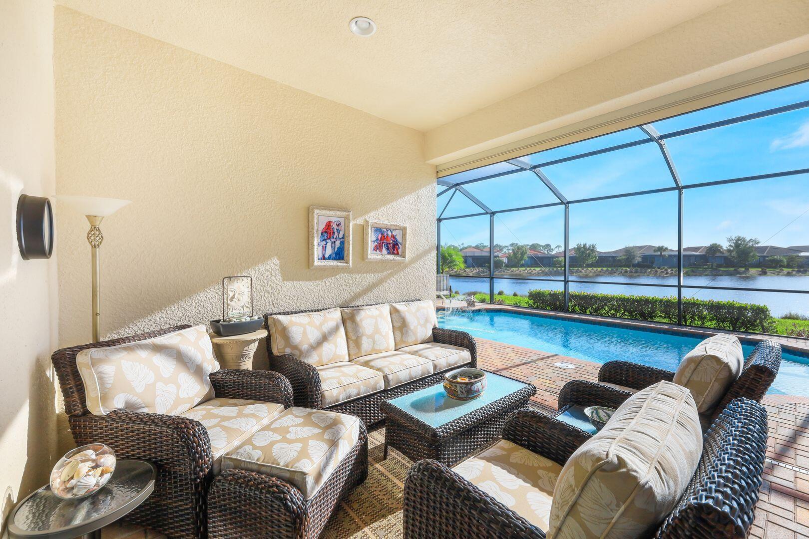 1433 Redona Way Naples, FL 34113 - Photo 32 of 50 a living room with furniture and a floor to ceiling window