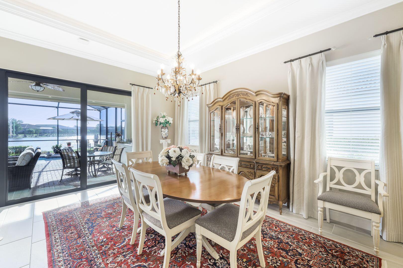 1433 Redona Way Naples, FL 34113 - Photo 7 of 50 a view of a dining room with furniture wooden floor and chandelier
