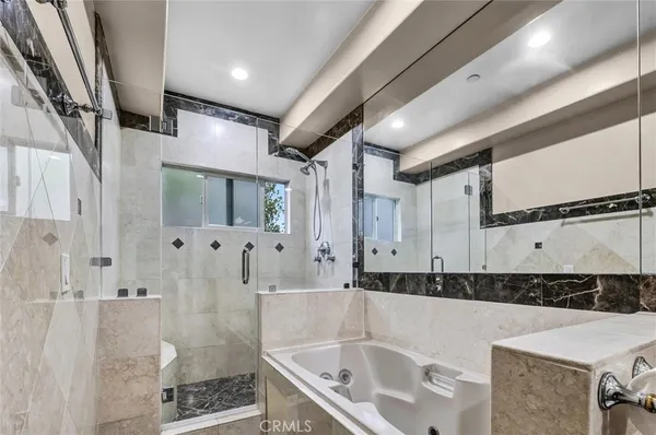 a bathroom with a tub sink and mirror