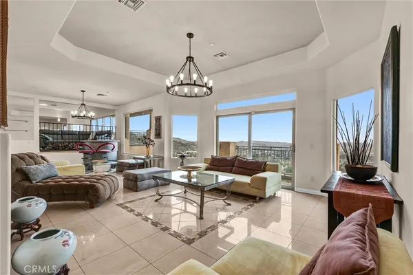 a living room with furniture chandelier and a large window