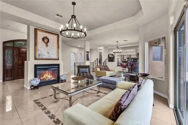 a living room with furniture a fireplace and a chandelier