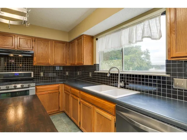 a kitchen with a large window cabinets and stainless steel appliances