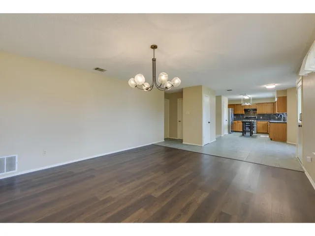 a view of a livingroom with a furniture wooden floor and a chandelier