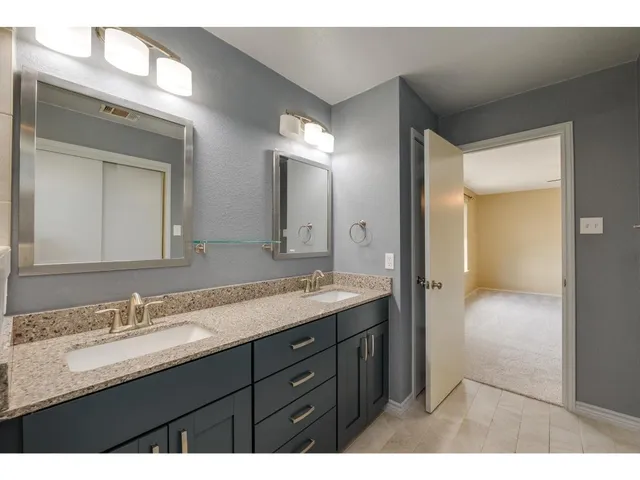 a bathroom with a granite countertop sink vanity and a mirror