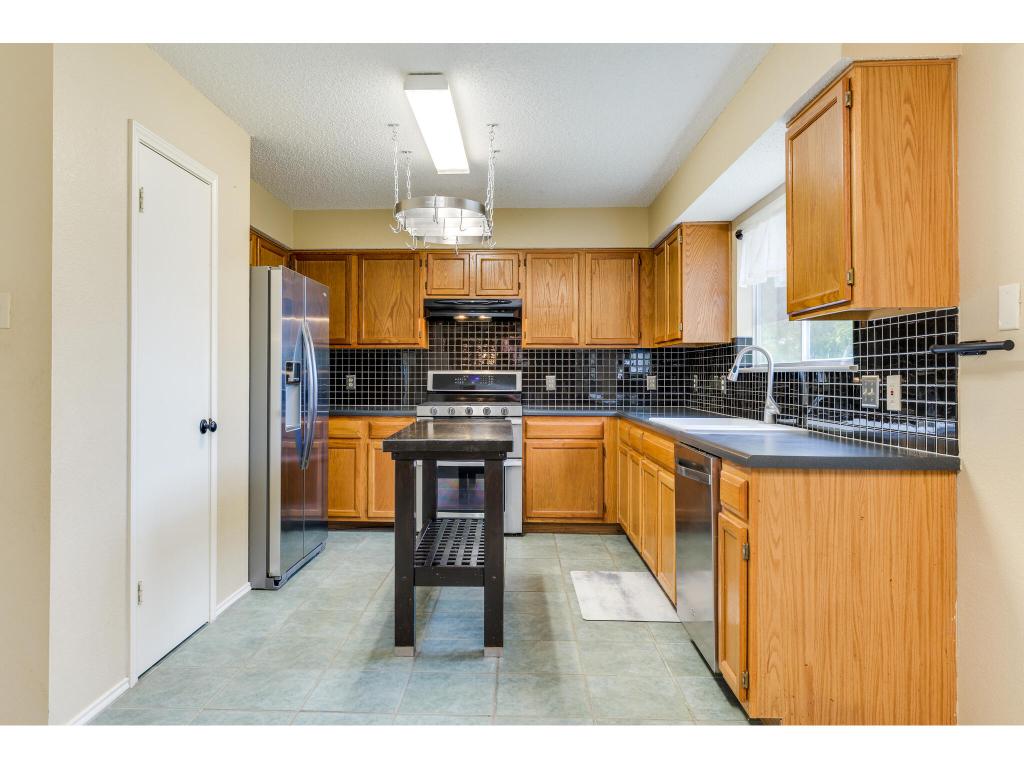 3912 Lemos Drive Austin, TX 78728 - Photo 10 of 40 a kitchen with granite countertop a stove a sink and a refrigerator