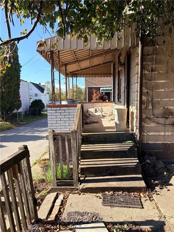 a view of a patio with a table and chairs with wooden floor and fence