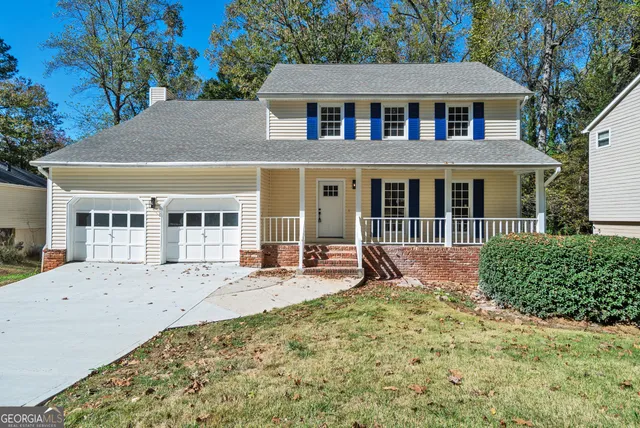 a front view of a house with a yard outdoor seating and garage
