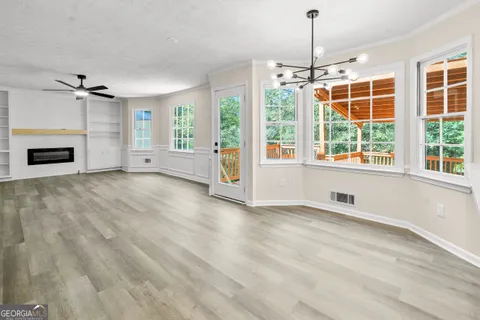 an empty room with windows and chandelier