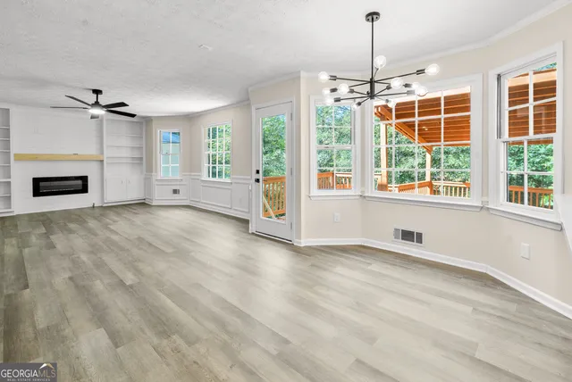 an empty room with windows and chandelier