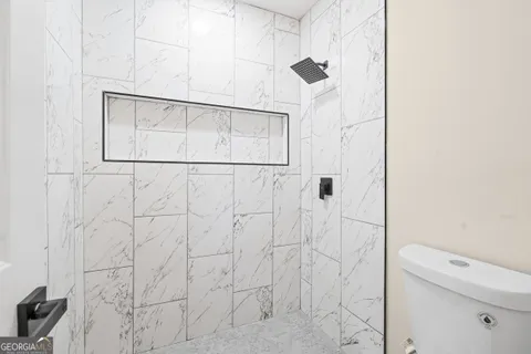 a bathroom with a white shower and a toilet sink