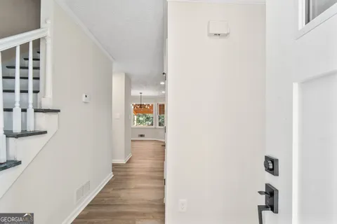 a view of a hallway with wooden floor and staircase