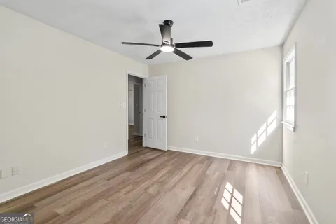 a view of empty room with wooden floor
