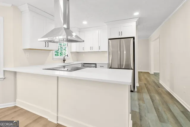 a kitchen with stainless steel appliances a sink cabinets and wooden floor