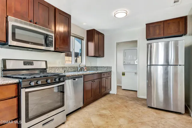 a kitchen with stainless steel appliances granite countertop a stove microwave and refrigerator