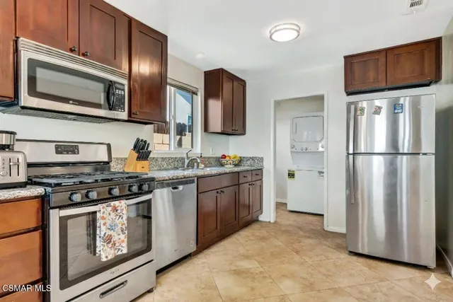 a kitchen with stainless steel appliances granite countertop a stove a refrigerator and a microwave