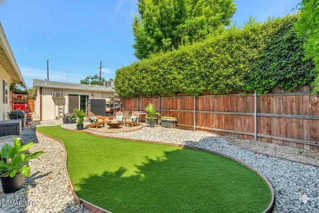 a backyard of a house with table and chairs