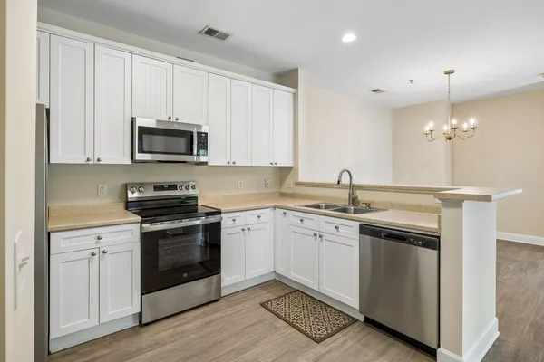 a kitchen with sink a microwave and cabinets