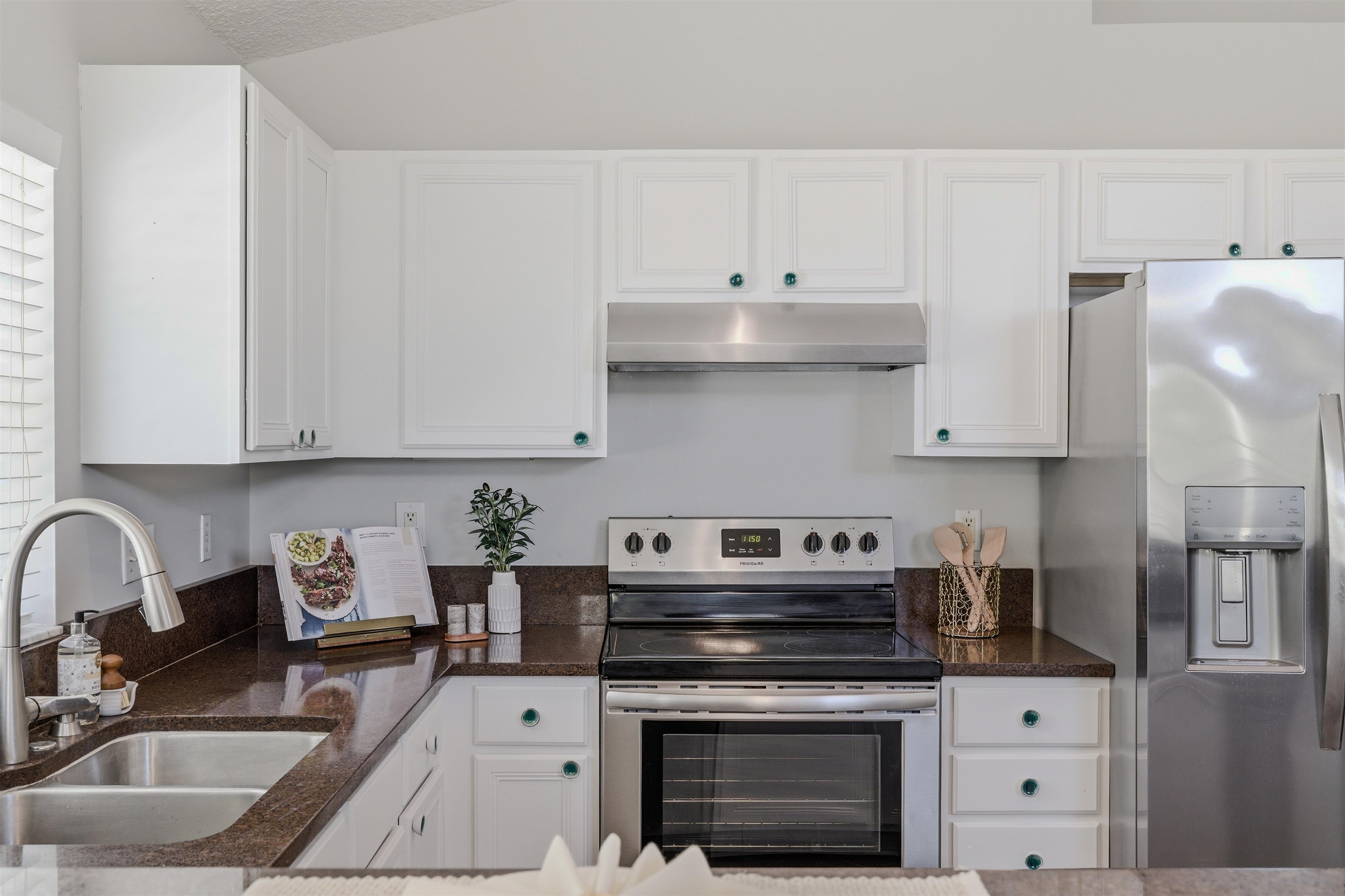 207 11th Street St. Augustine, FL 32080 - Photo 11 of 28 a kitchen with stainless steel appliances granite countertop a stove white cabinets a sink and dishwasher