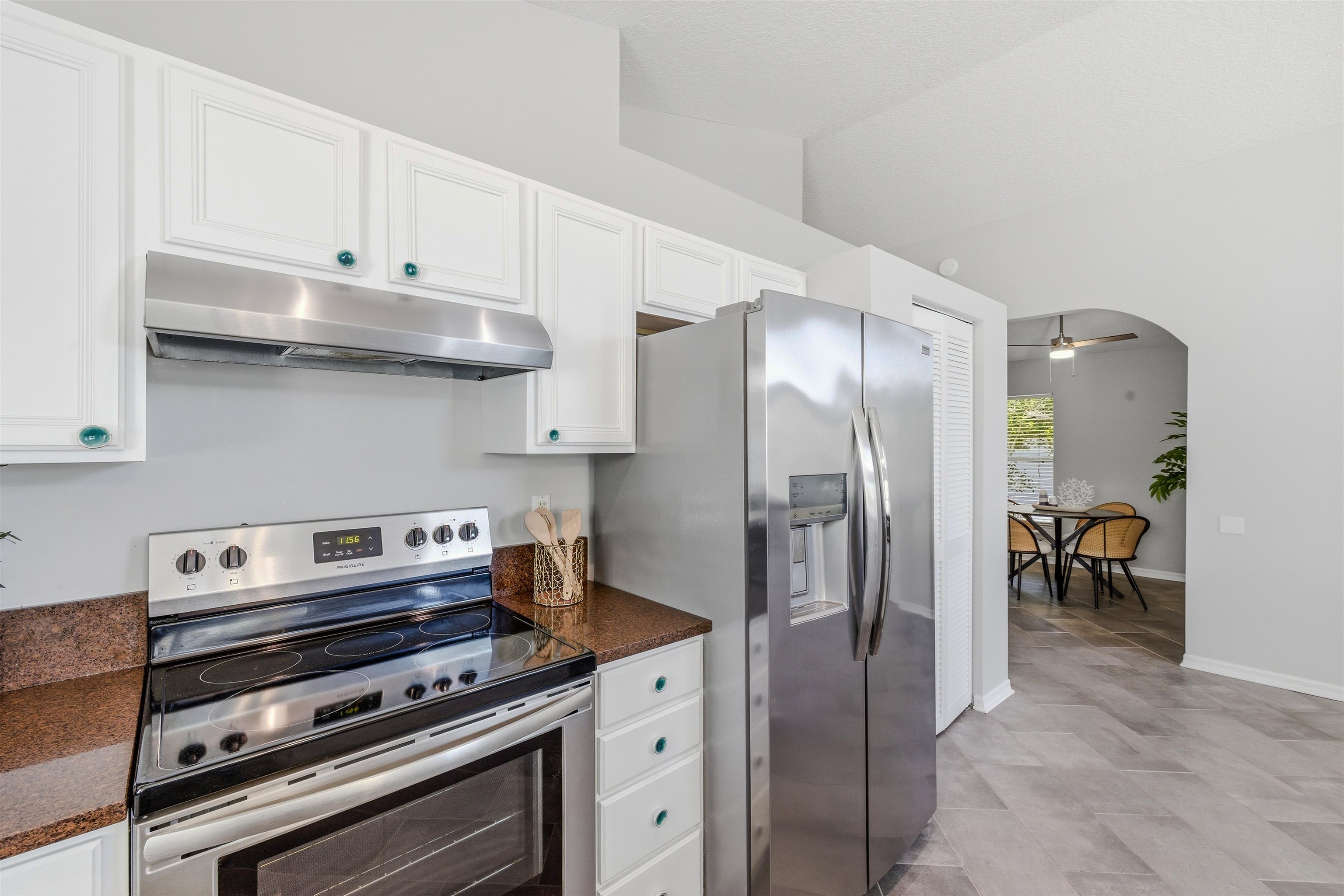 207 11th Street St. Augustine, FL 32080 - Photo 12 of 28 a kitchen with stainless steel appliances granite countertop a stove and a refrigerator