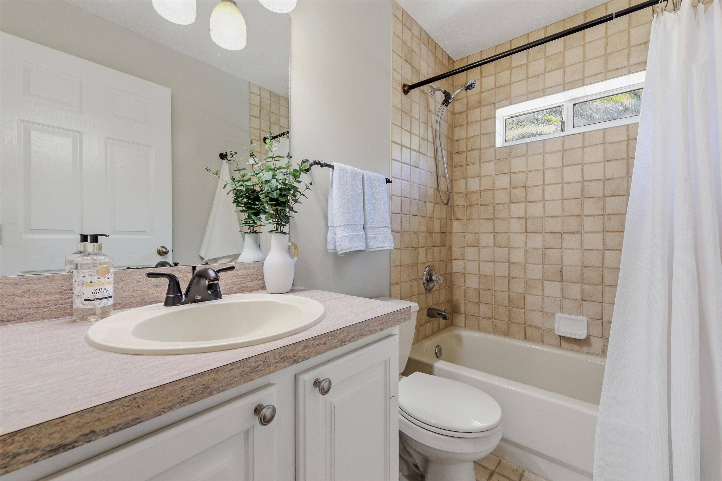 207 11th Street St. Augustine, FL 32080 - Photo 23 of 28 a bathroom with a sink a toilet and shower