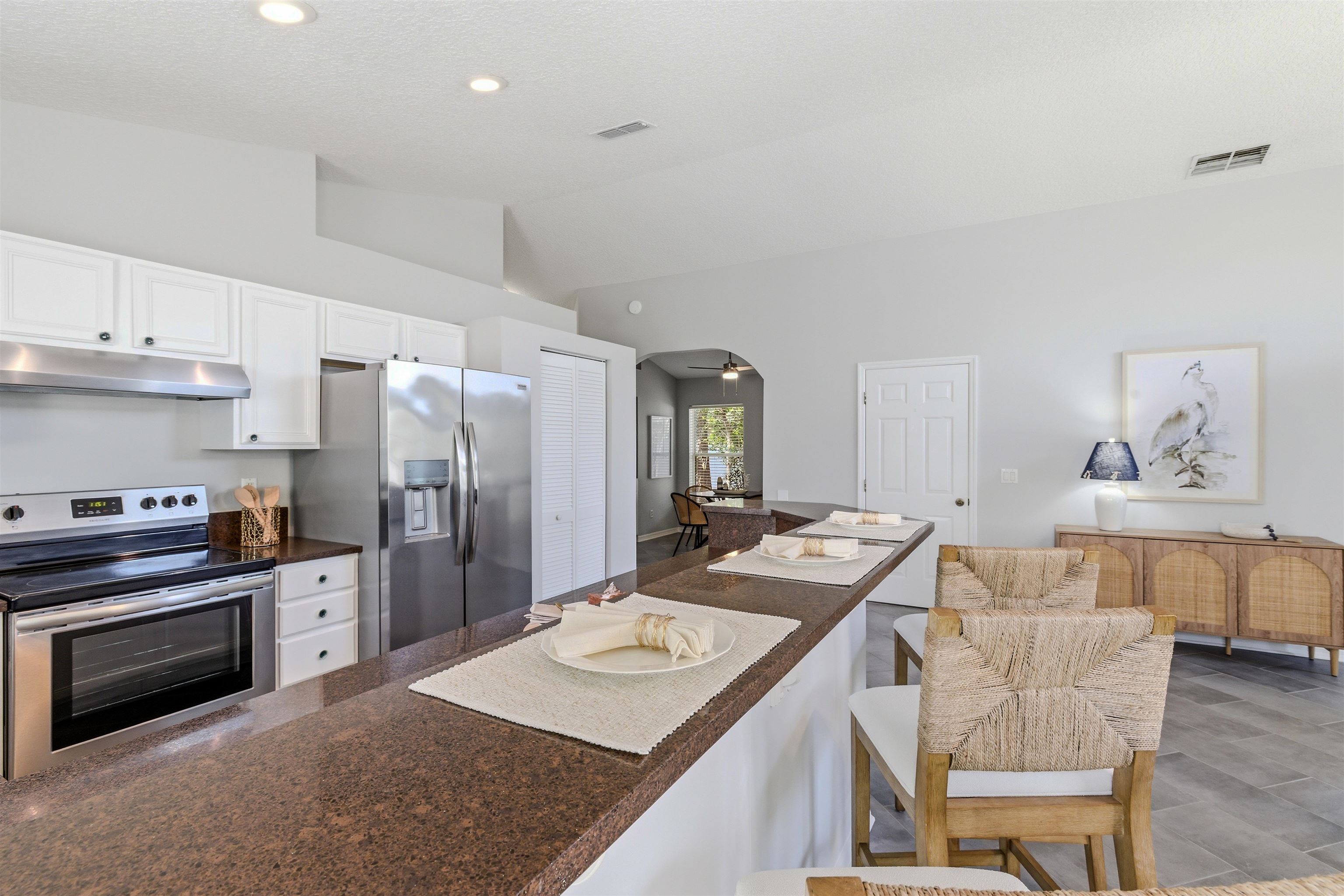 207 11th Street St. Augustine, FL 32080 - Photo 10 of 28 a kitchen with stainless steel appliances kitchen island granite countertop a sink a stove a refrigerator and cabinets