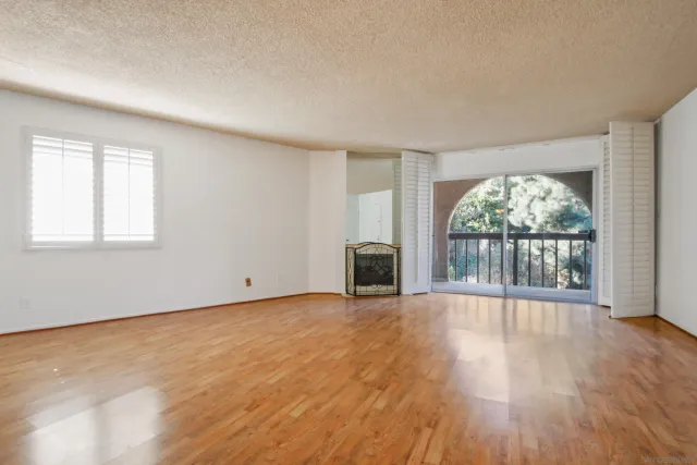 an empty room with wooden floor and fireplace