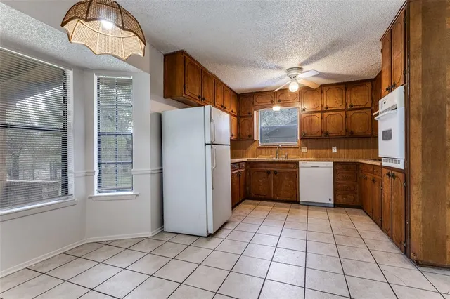 a kitchen with a refrigerator a sink dishwasher and cabinets