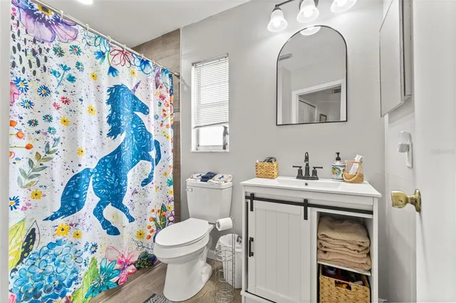 a bathroom with a granite countertop sink mirror vanity and toilet