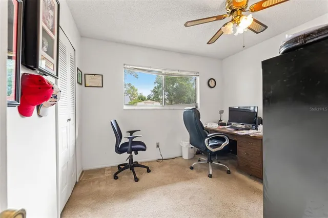 a view of a workspace with furniture and a window
