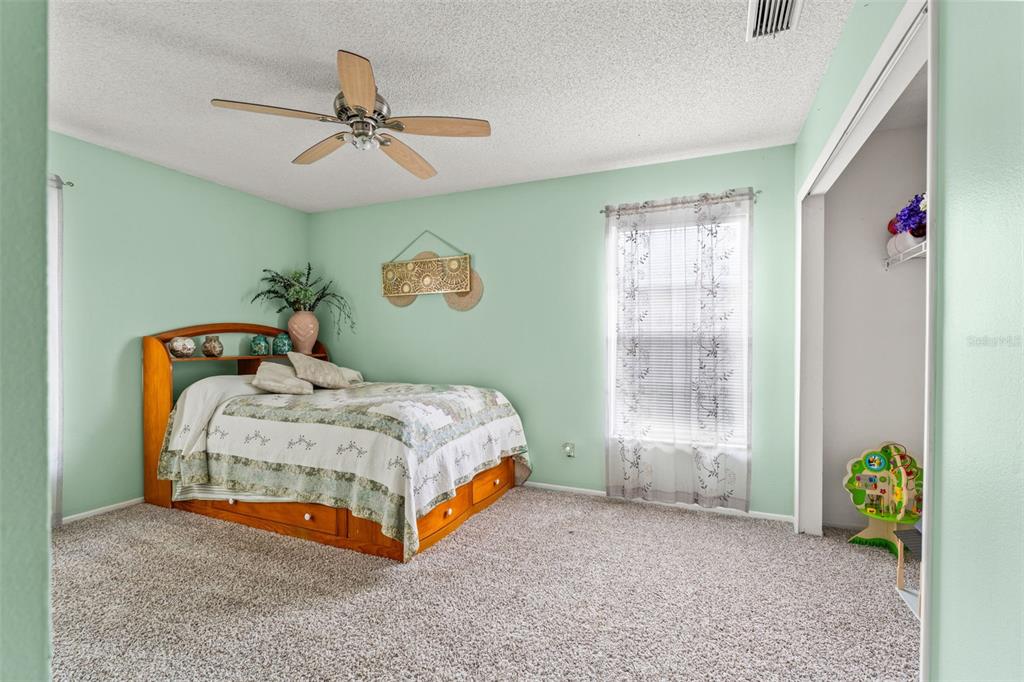 5078 Kenmore Street Spring Hill, FL 34608 - Photo 22 of 31 a bedroom with a bed and a chandelier