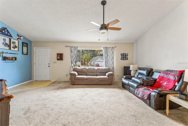 a living room with furniture a ceiling fan and a rug