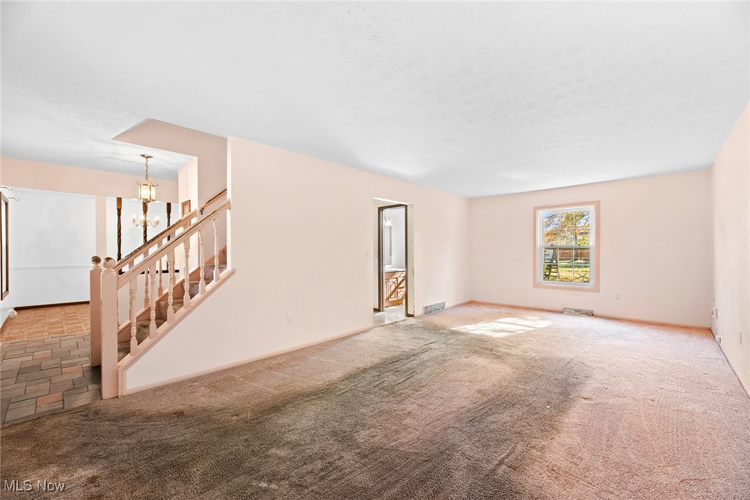 3550 Boston Road Brunswick, OH 44212 - Photo 13 of 37 Unfurnished living room with carpet flooring and a chandelier