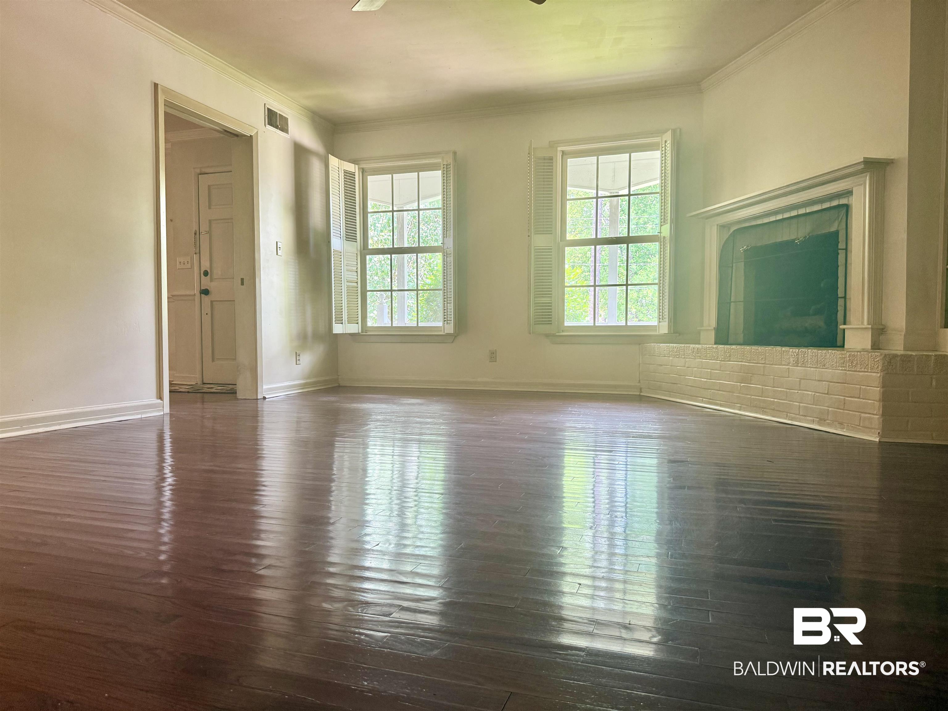 1412 Poplar Avenue Brewton, AL 36426 - Photo 16 of 32 Unfurnished living room with dark wood-style floors, crown molding, baseboards, and ceiling fan