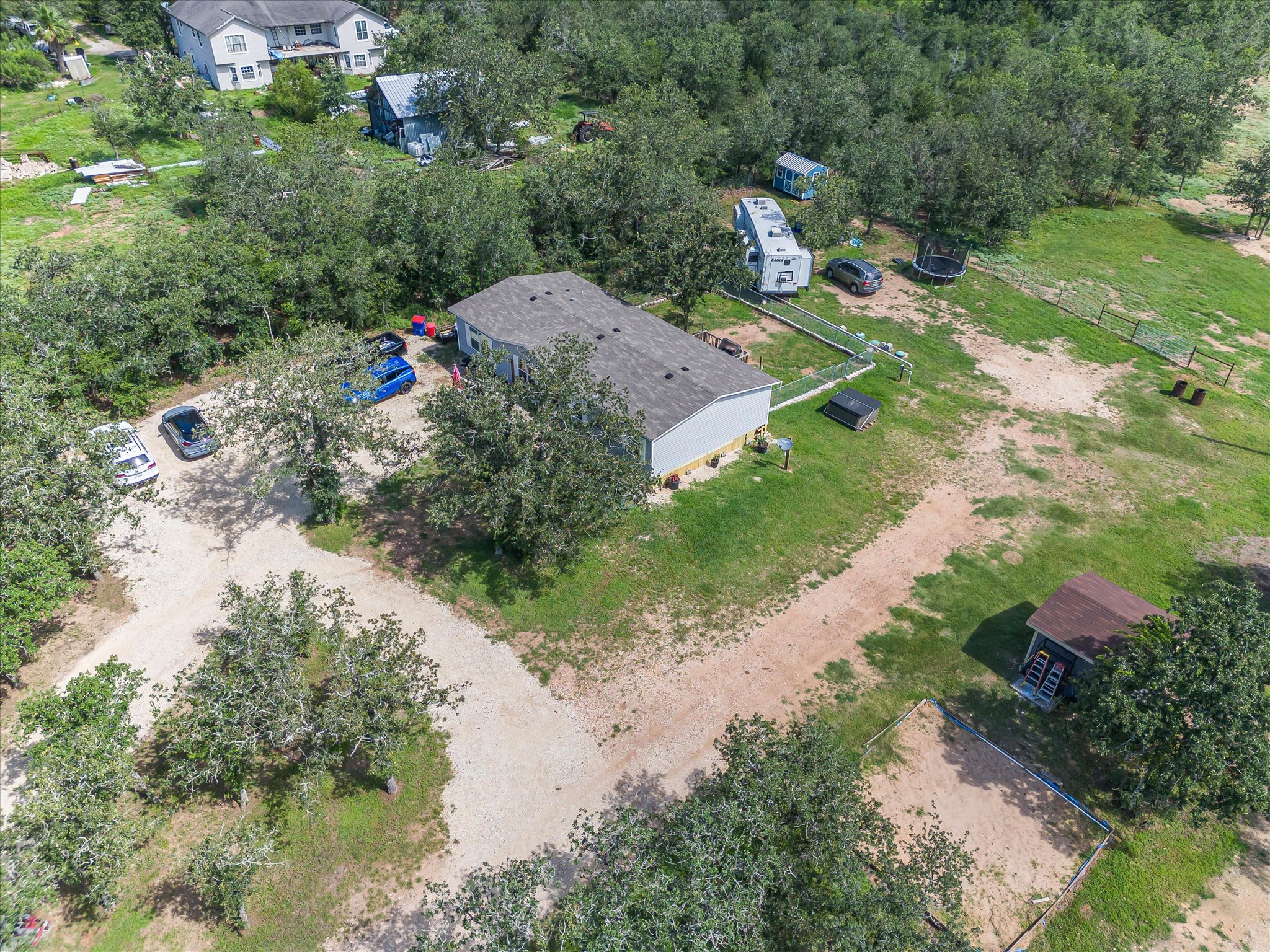 2755 Washburn Road Luling, TX 78648 - Photo 32 of 40 An aerial view captures the vast, tree-dotted property with a private drive leading to multiple structures.
