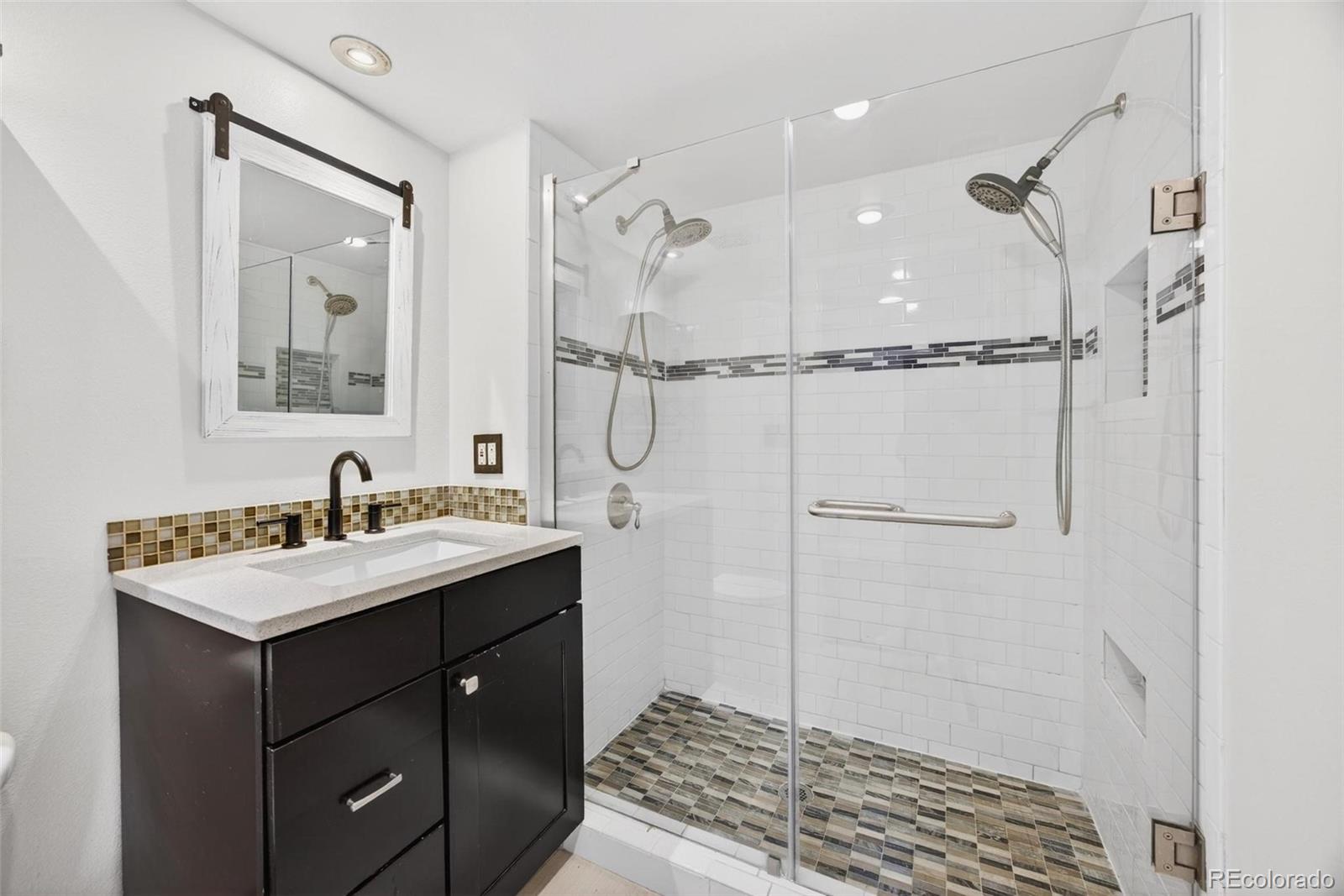 1150 Inca Street, Unit 46 Denver, CO 80204 - Photo 13 of 45 a bathroom with a sink a mirror and a shower